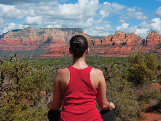 woman sitting crisscrossed looking at mountain